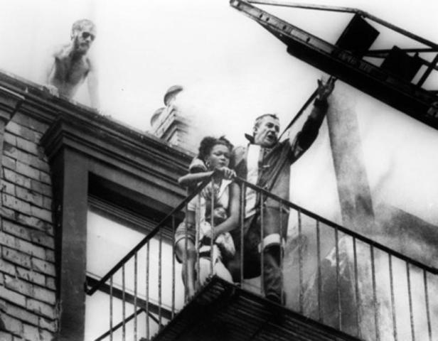 Boston firefighter Robert O'Neill is seen with Diana Bryant and Tiara Jones, age 2 years, and helicopter pilot Joe Green, above, prior to the fire escape collapse that would kill Bryant, at 129 Marlborough St. on July 22, 1975. Photo Stanley Forman